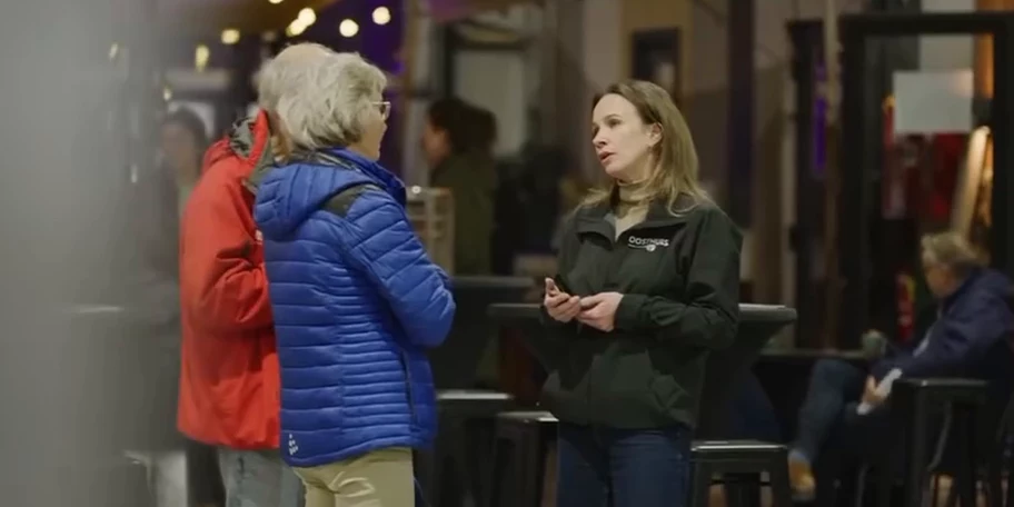 Een medewerker van Oosthuis in gesprek met twee bezoekers in de bouwhal